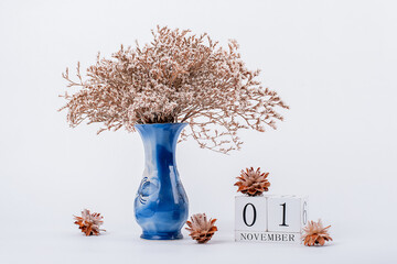 wooden calendar and a vase of flowers in the office. November 1