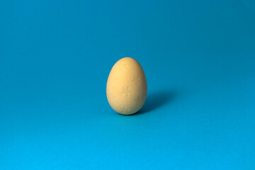 White chocolate with stars Easter egg on blue pastel pastel background. Close up.