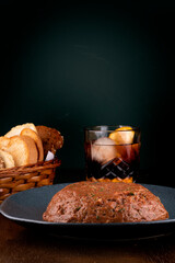 hackepeter - pairing a German dish of seasoned raw meat with a Negroni cocktail and bread basket. on wooden table