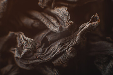 Close-up of a dry leaf of black Ceylon tea in macro. Extreme macro dark tea background