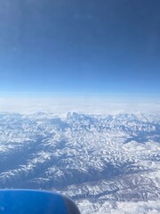 Aerial view of snow capped mountains. airplane wing above earth. Photos from the windows of the plane that are going to Airport.