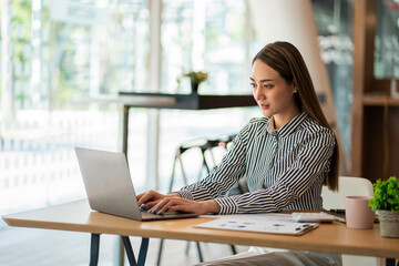 A business analyst or accountant calculates and examines financial documents. Asian businesswoman...