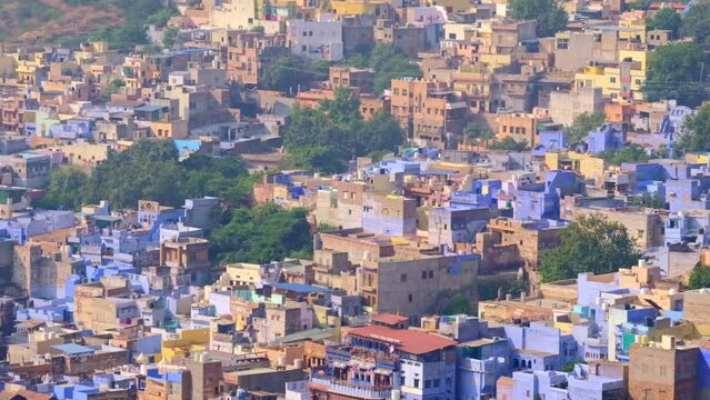 Jodhpur the Blue City aerial view. Blue painted houses and birds flying in the morning above brahmin houses, view from Mehrangarh Fort, Rajasthan, India. Camera zoom out