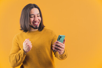 Happy excited caucasian man smiling while looking at his smartphone. Online game transmission. Technology concept. High quality photo