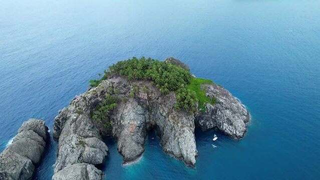 Aerial view over the Ilheu de Santana island, in cloudy Sao Tome - tilt, drone shot