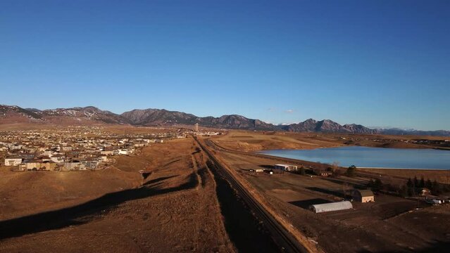 Railway leading from Denver to the foothills of Boulder Colorado during golden hour, aerial