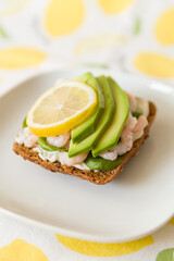 Homemade sandwich with fresh shrimps, avocado, cream cheese and lemon