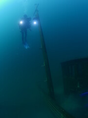 scuba divers exploring shipwreck scenery underwater ship wreck deep blue water ocean scenery of...