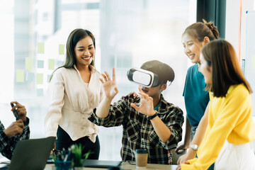 Asian startup group using virtual reality glasses in the workplace.