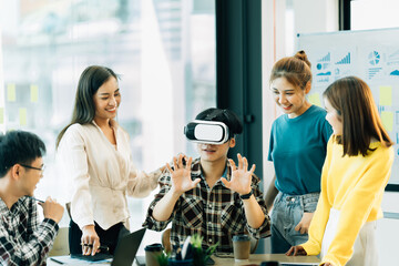 Asian startup group using virtual reality glasses in the workplace.