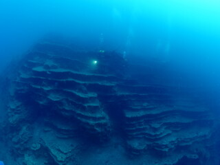 Naklejka na ściany i meble scuba divers around a reef underwater deep blue water big rock 