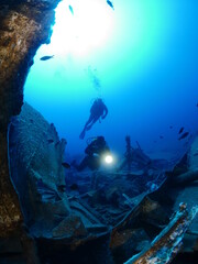 Fototapeta na wymiar scuba divers exploring shipwreck scenery underwater ship wreck deep blue water ocean scenery of metal underwater