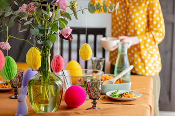 Obraz na płótnie Canvas woman sets the Easter table. for dinner. True lifestyle