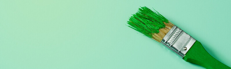 a green paintbrush with green paint, web banner