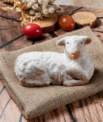 Traditional easter sweet lamb cake with powdered sugar, willow, eggs  served on a sack on a wooden...