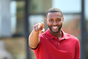 Happy man with black skin pointing at camera
