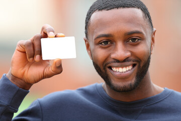 Happy man with black skin showing blank credit card