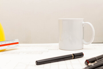 Mockup of architectural concept, Drawing tool and coffee on drawing of blueprint with safety helmet