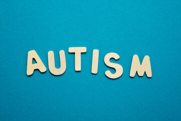 Isolated word Autism on blue background.