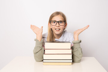 Amazed girl in glasses with pile of books isolated on white background.