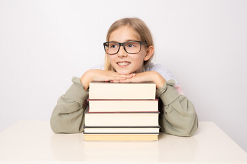 Beautiful smiling positive cheerful girl in glasses with pile of books isolated on white background.