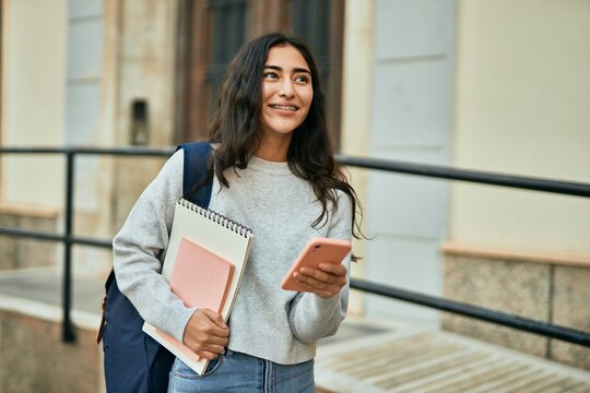 Young middle east student girl smiling happy using smartphone at the city.