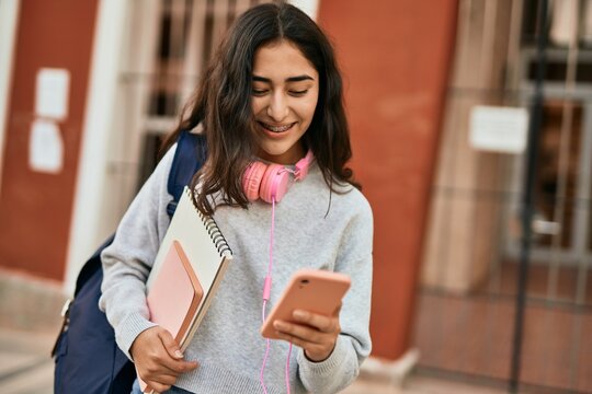 Young middle east student girl smiling happy using smartphone at the city.