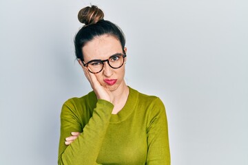 Young hispanic girl wearing casual clothes and glasses thinking looking tired and bored with depression problems with crossed arms.