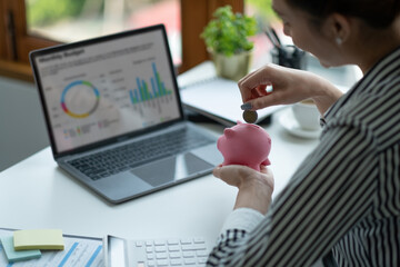 Asian woman hand putting money coin into piggy for saving money wealth and financial concept.