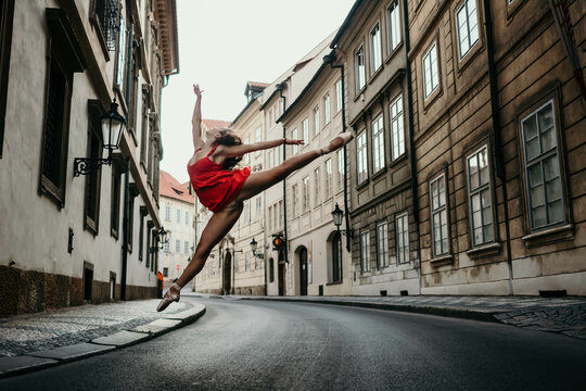 Fototapeta Ballerina jumping over street in old town