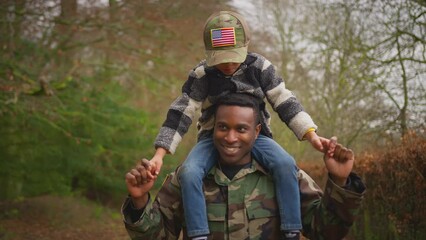 American soldier in uniform returning home to family on leave carrying son wearing army cap on shoulders - shot in slow motion - Powered by Adobe