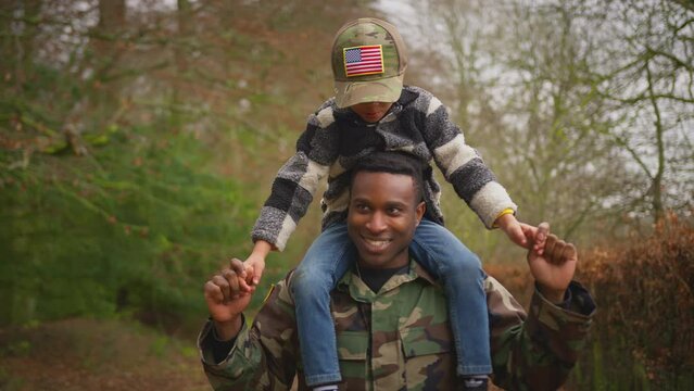 American soldier in uniform returning home to family on leave carrying son wearing army cap on shoulders - shot in slow motion