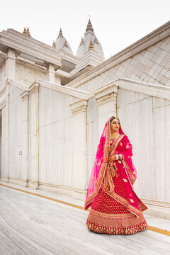 Indian bride standing near white building