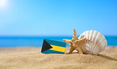 Foto op Plexiglas Tropical beach with seashells and Bahamas flag. The concept of a paradise vacation on the beaches of Bahamas. © Nikita