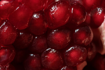Juicy and ripe pomegranate seeds. Macrophotography. Red pomegranate seeds close-up.