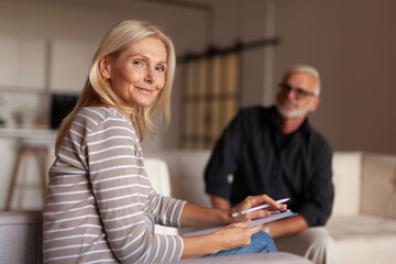 Woman psychologist smiling at a psychotherapy session. Helping a mature man with depression and...