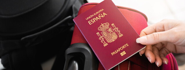 Horizontal banner or header Unrecognizable female hand catching a Spanish European passport on...