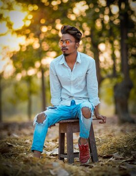 Man sitting on brown wooden stool in the woods