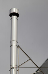 Stainless steel chimney construction on roof. Heat equipment.