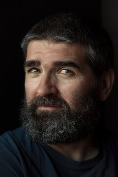 Man with a beard against dark background