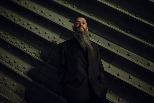 Man with long beard wearing dark suit