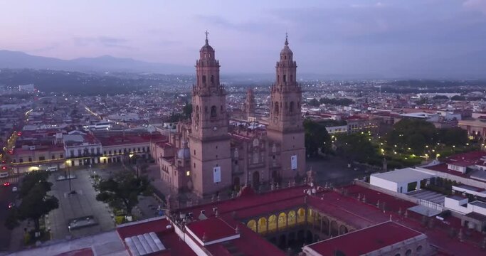 Drone flies over Morelia, Mexico at sunrise. Drone panning right around the cathedral with the waking city being revealed behind.