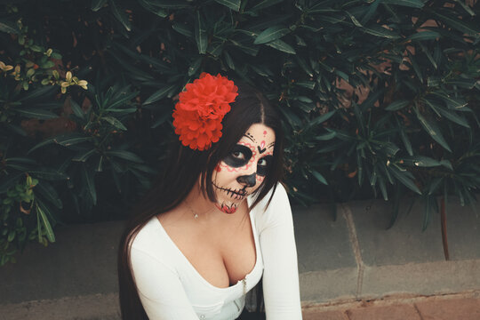 Portrait of Hispanic woman with skull candy face paint
