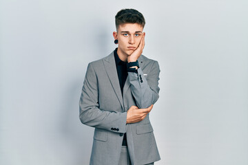 Young caucasian boy with ears dilation wearing business jacket thinking looking tired and bored with depression problems with crossed arms.