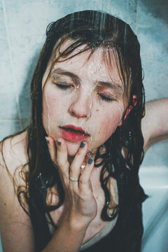 Portrait of woman in shower closing her eyes