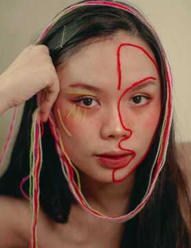 Portrait of woman with yarn outlining half of her face