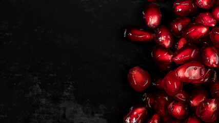 Pomegranate seeds close-up. Red on black. Macrophotography. Healthy food and vitamins.