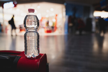 Close-up plastic bottle of water on a trolley in airport with copy space.