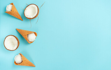 Organic coconut ice cream cones on bright blue background. Flat lay, copy space.