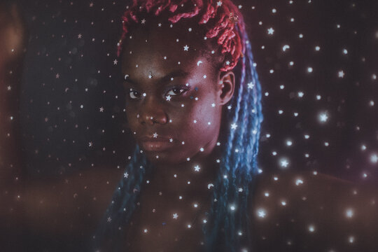 Portrait of young Black woman with colorful dreads in Nebula themed studio